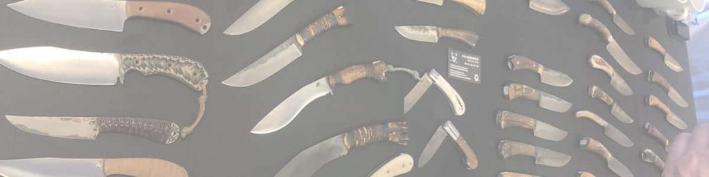 Sélection de couteaux fixes et de couteaux pliants présentés lors d'un salon coutelier